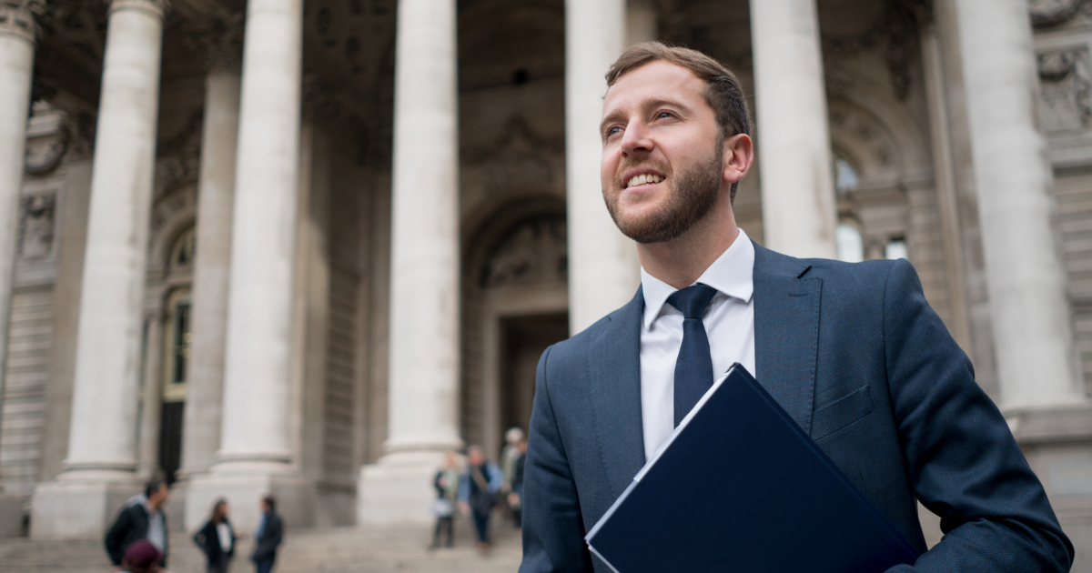 Image of a man in front of a bank. He's an expert on open banking in the payments industry