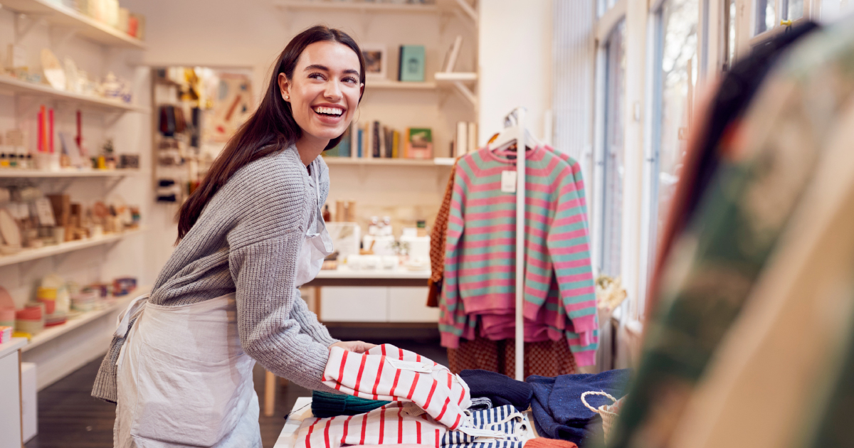 Small retail merchant organizing products in a boutique store, representing how embedded lending helps merchants access capital through the platforms they use.