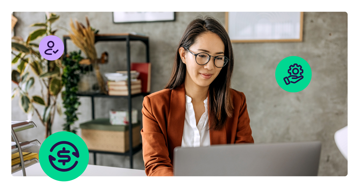 A professional woman working at her laptop in a modern office, representing the payments industry's shift toward more realistic AI expectations and the rise of seamless, software-led merchant onboarding.