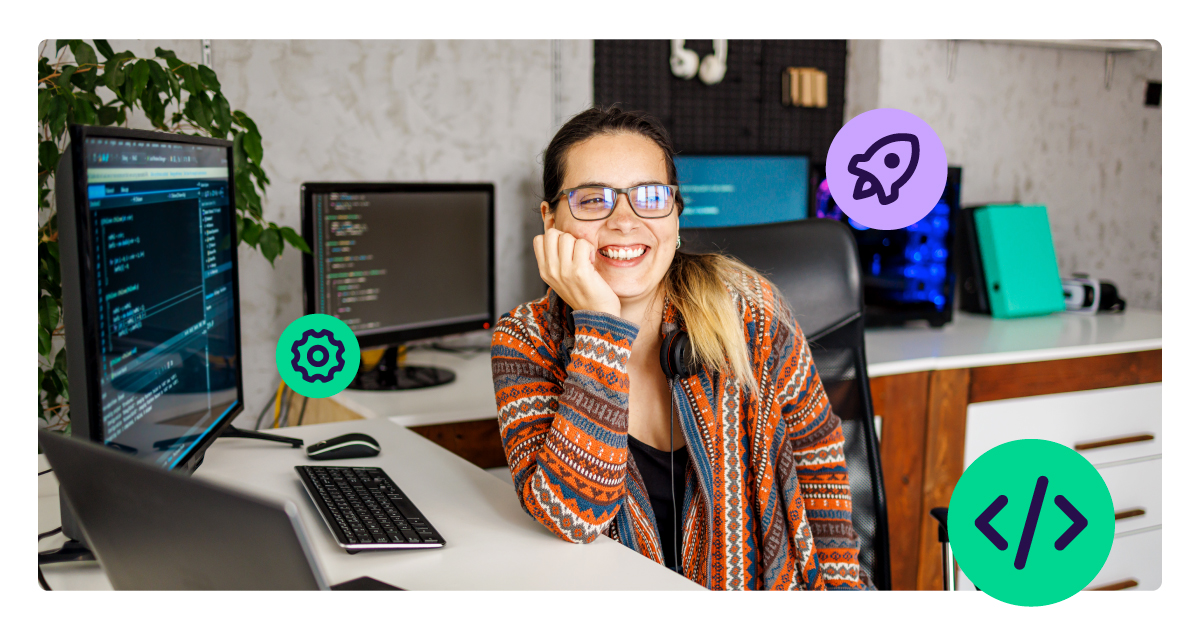 Smiling software developer wearing headphones and glasses, seated at a desk with multiple computer monitors displaying code in a modern workspace.