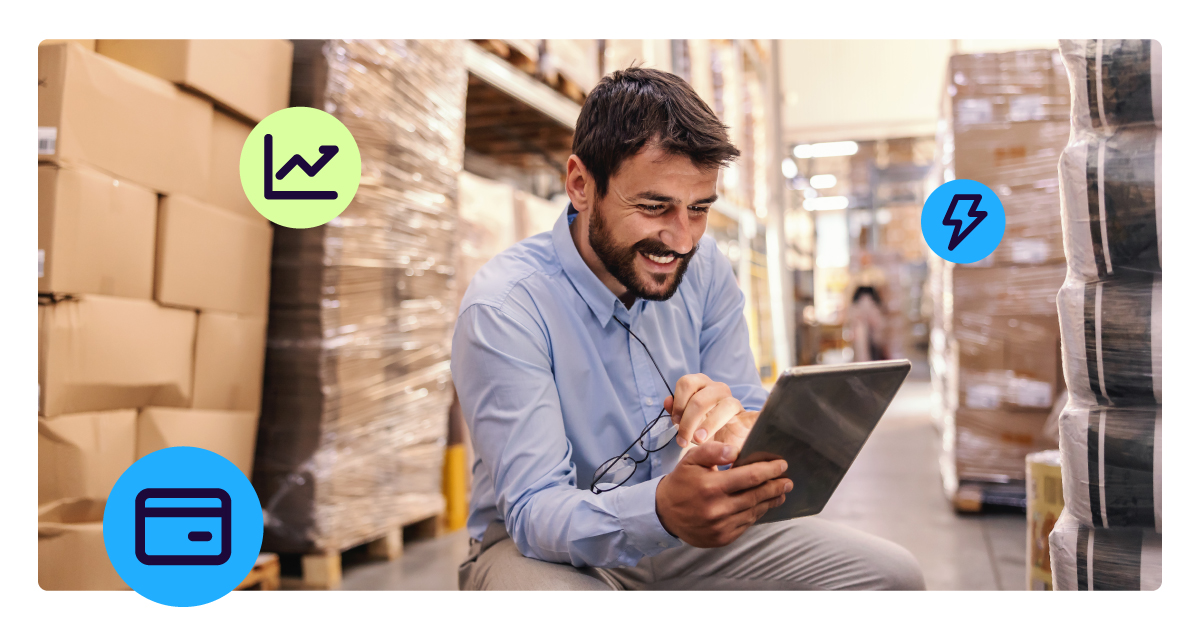 B2B merchant in a warehouse using a tablet to manage payments and transactions, representing faster funding and improved visibility with commercial card acceptance.