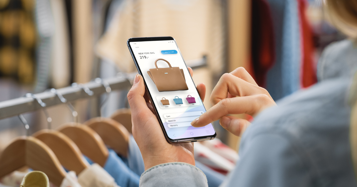 Shopper using a mobile phone to browse products in a retail store, representing digital commerce, tokenized payments, and the future of seamless checkout experiences.