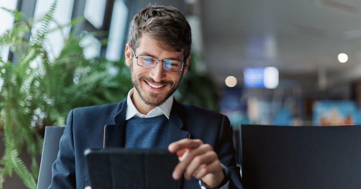 Business professional using a tablet with embedded finance icons overlaid, representing how SaaS platforms deliver payments, lending, insurance and AI-driven financial services directly in-platform.