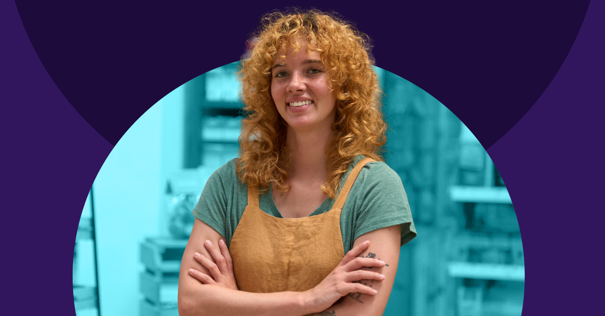 Lady stands crossed arms smiling.