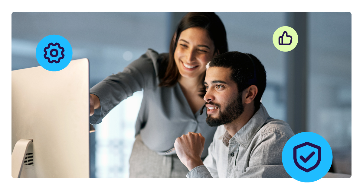 Two professionals reviewing data on a computer screen, representing automated underwriting and compliance processes in payments.