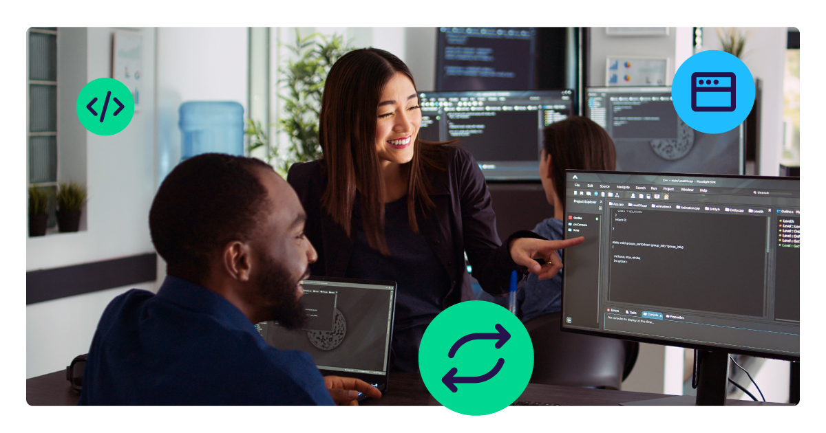 Two office workers smile at a computer in a modern setting