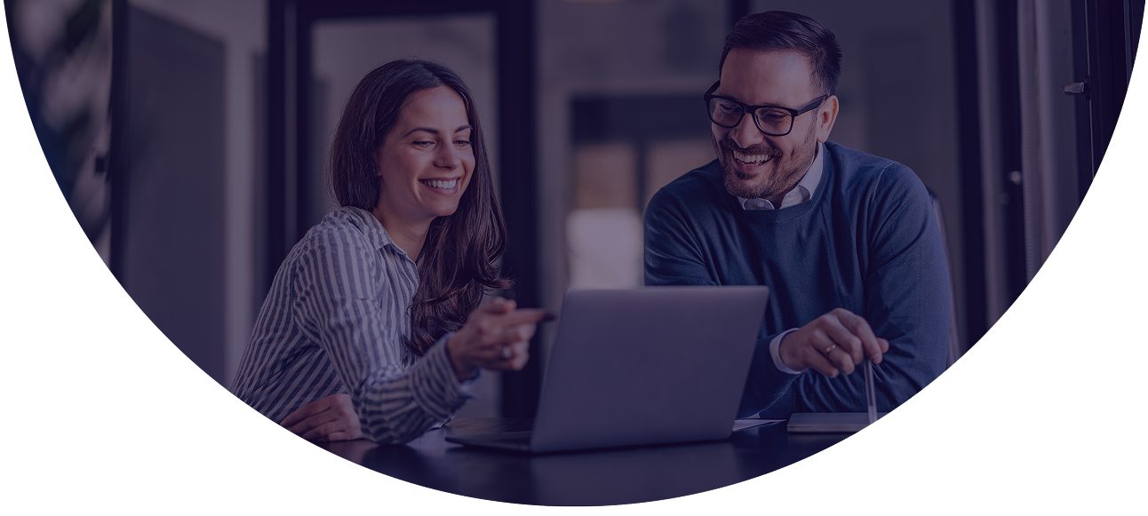 Two payments professionals smiling while reviewing residuals management data...using NMI Merchant Central's automated payout and reporting tools.