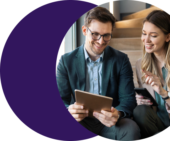Two payments professionals smiling while reviewing residuals reconciliation data on a tablet, demonstrating how Merchant Central replaces manual processes with automated accuracy and portfolio visibility.