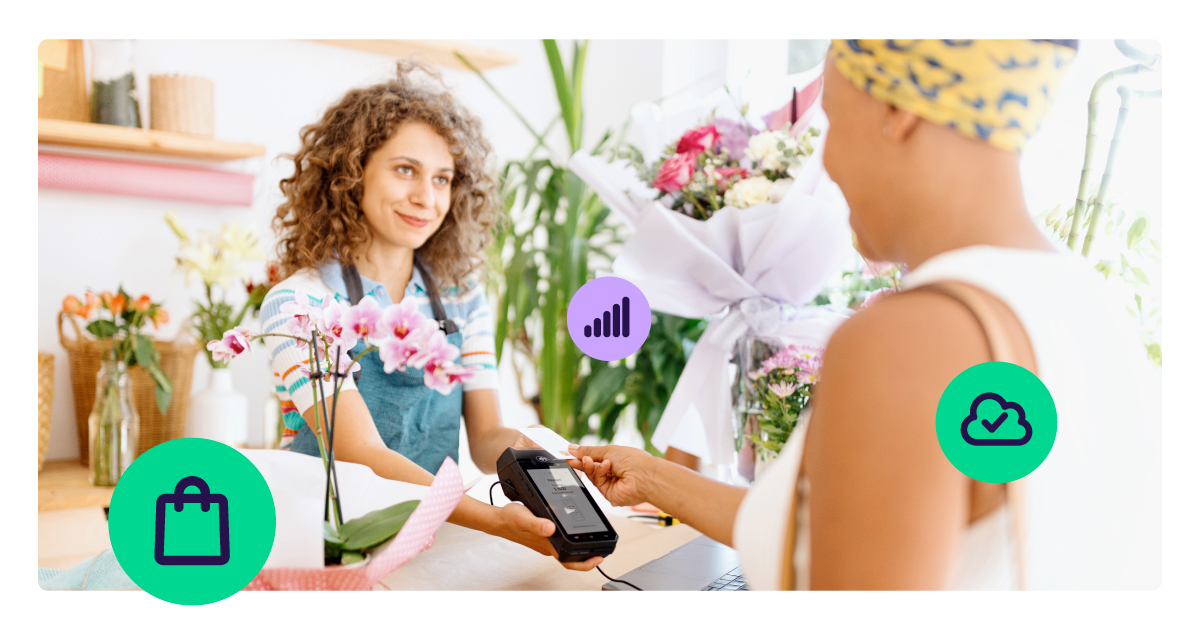 A florist takes a contactless card payment on a handheld smart POS terminal in a flower shop