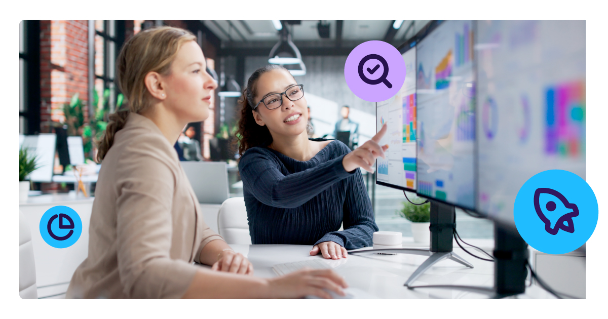 Two business professionals review underwriting data on a large screen in a modern office